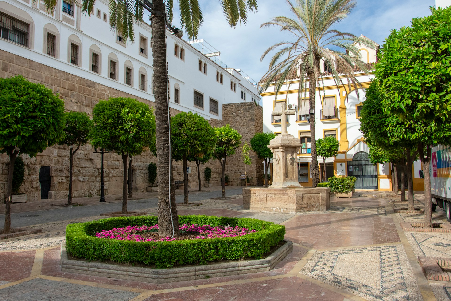Marbella Old Town - Historic european plaza with palm trees, fountain, and white buildings.